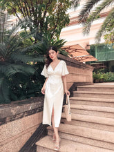 Silk midi dress with front slit and flutter sleeves, featuring button-down detailing